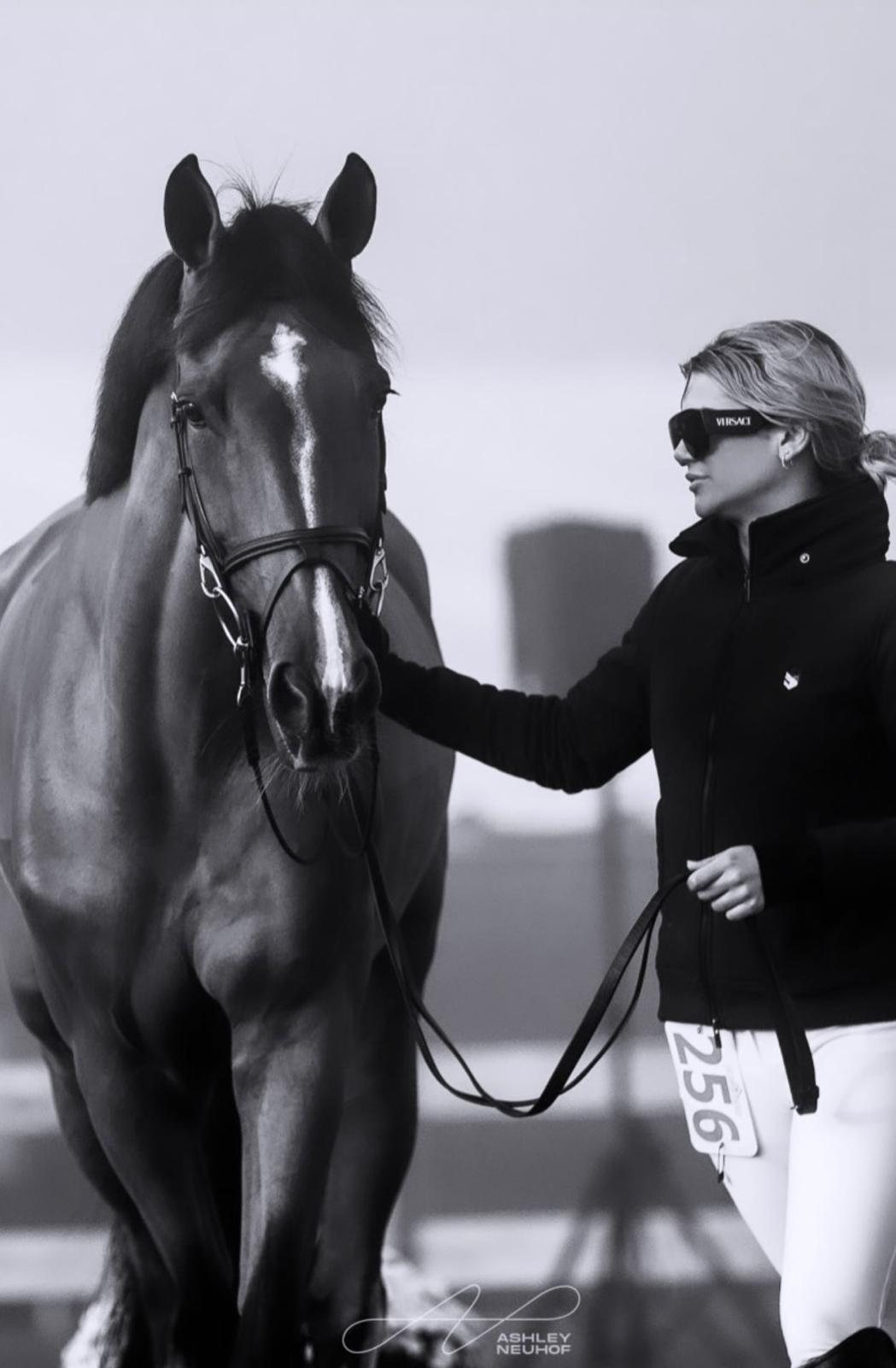 Teddi Pritzker walking her horse in the collecting ring, in black and white.